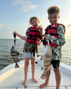 Children wearing life jackets showing their catches